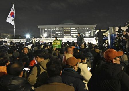 　昨年１２月４日、韓国の尹錫悦大統領が宣言した「非常戒厳」に反発し、ソウルの国会周辺に集まった人々（共同）