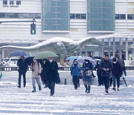 　積雪した福井駅前を歩く人たち＝９日午前、福井市