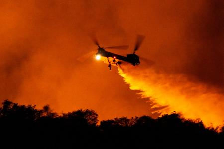 　米カリフォルニア州ロサンゼルスの山火事で水を投下するヘリコプター＝１１日（ＡＰ＝共同）