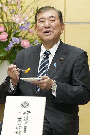 　福島県特産の「あんぽ柿」を試食する石破首相＝１６日午後、首相官邸