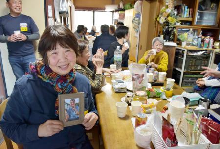 　しのぶ会で、山根敏博さんの遺影を手にする妻けい子さん＝１９日、石川県輪島市