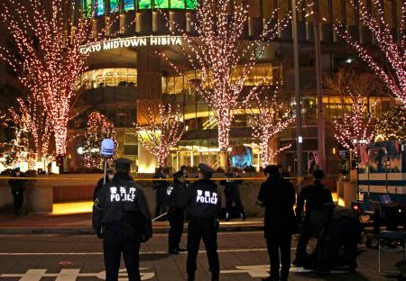 　「東京ミッドタウン日比谷」前で警戒する警察官＝１９日夜、東京都千代田区