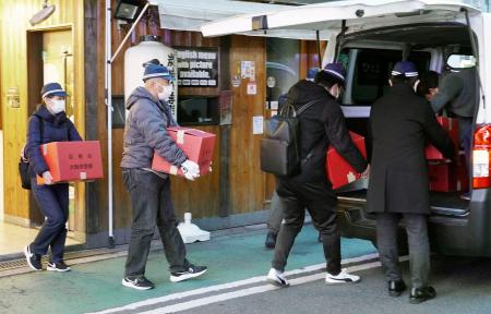 　家宅捜索し、段ボール箱を運び出す大阪府警の捜査員ら＝１８日、大阪市北区