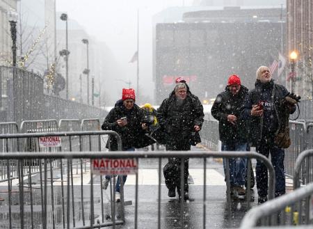 　雪が降る中、米国のトランプ新大統領の集会に急ぐ支持者＝１９日、ワシントン（共同）