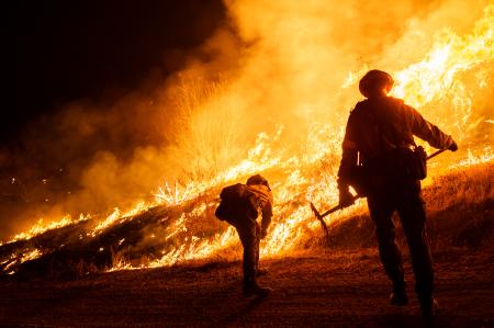 　２２日、米ロサンゼルス北部郊外キャスティークで、山火事の消火活動をする消防士（ゲッティ＝共同）