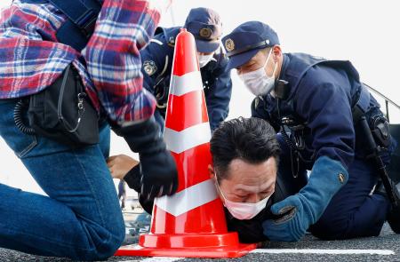 　静岡県警と愛知県警が合同で行った匿流による強盗事件の対応訓練で犯人（下）を取り押さえる警察官＝２４日午後、静岡県湖西市