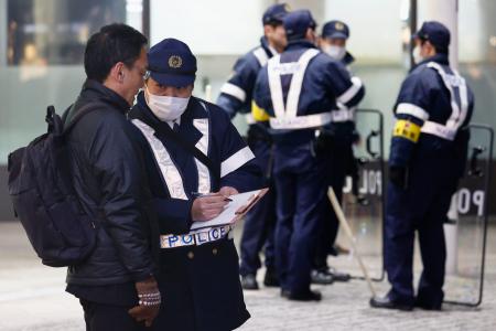 　ＪＲ長野駅前で聞き込みをする警察官＝２４日午後、長野市