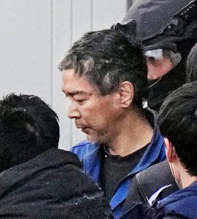 　ＪＲ長野駅前で男女３人が殺傷された事件で、捜査員に囲まれて自宅を出る容疑者＝２６日午前７時２４分、長野市