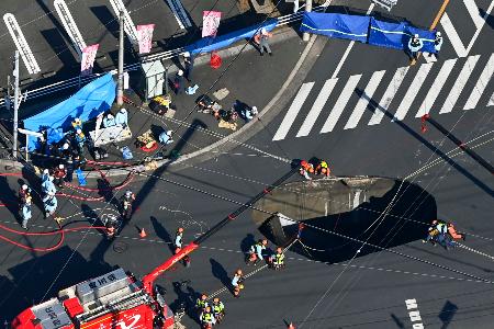 　道路が陥没した県道交差点にできた穴＝２８日午前１１時５７分、埼玉県八潮市（共同通信社ヘリから）