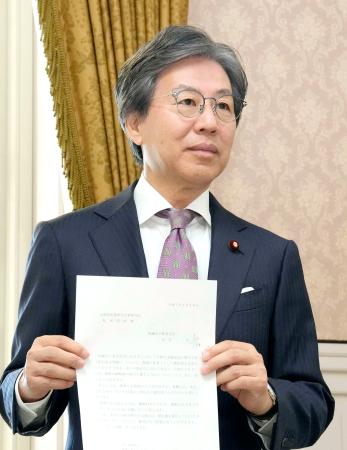 　衆院予算委で旧安倍派会計責任者の参考人招致が議決され、出席を求める文書を手にする立憲民主党の安住委員長＝３０日午前、国会