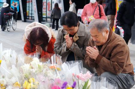 　福島県郡山市で１月に起きた受験生の死亡事故現場を訪れ、手を合わせる井上郁美さん（中央）、保孝さん（右）夫妻＝１日午後