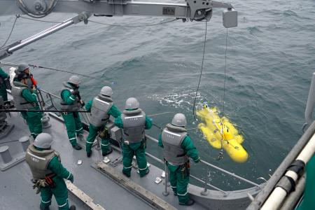 　無人機で機雷を処分するデモンストレーションを報道陣に公開する海上自衛隊の隊員ら＝２日午前、三重県松阪市沖の伊勢湾