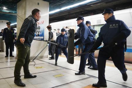 　警視庁新宿署と小田急電鉄が実施した訓練で、犯人役（左手前）を取り囲む署員ら＝４日午前、小田急新宿駅