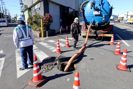 　県道が陥没しトラックが転落した事故現場付近で、マンホールから汚水をくみ上げるポンプ車＝４日午前、埼玉県八潮市