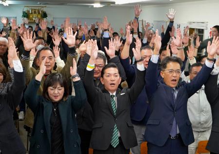 　沖縄県浦添市長選で４選を果たし、万歳する松本哲治氏（前列中央）＝９日夜、浦添市