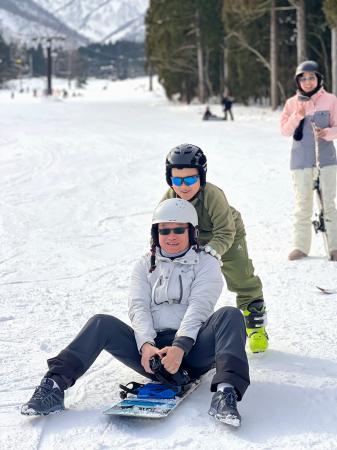 　中国広東省から長野県白馬村のスキー場を訪れ、長男と雪遊びを楽しむ葉華維さん（手前）＝１月（葉さん提供・共同）