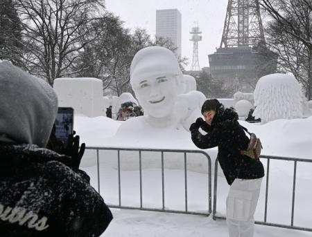 　「さっぽろ雪まつり」最終日、大谷翔平選手の雪像の前で記念撮影する人＝１１日午後、札幌市