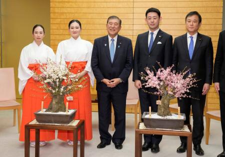 　福岡・太宰府天満宮の「梅の使節」から紅白２種類の梅の盆栽を贈られた石破首相（中央）＝１４日午後、首相官邸