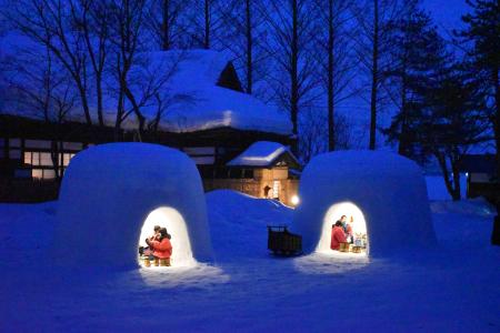 　暖かな光が雪景色に浮かんだ「かまくら」。秋田県横手市内で約６０基に明かりがともる＝１４日夕