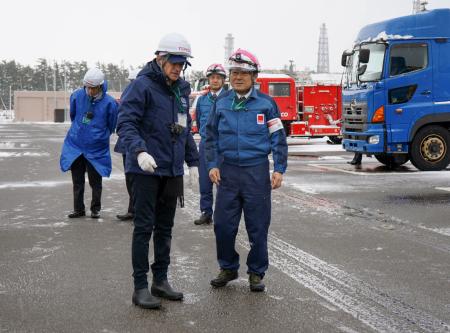 　新潟県の東京電力柏崎刈羽原発で、緊急時車両置き場を視察するＩＡＥＡのグロッシ事務局長（手前左）。右は同原発の稲垣武之所長＝１８日午後