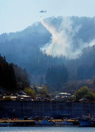 　岩手県大船渡市三陸町綾里の山林火災現場で続く消火活動＝２１日午前９時３９分