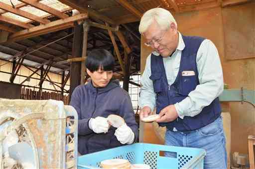 河津良隆さん（右）からヒノキの加工技術を学ぶ當房こず枝さん＝南小国町