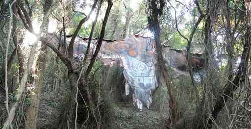 木立の間に現れる皮に描かれた絵画「皮トンビ」。原始の生物から、見つめられているような感覚に襲われる＝２０１９年、高松市