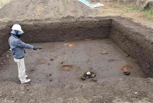 発掘調査で見つかった菊池一族の館跡とみられる遺構。柱があった穴を三つ確認できる。赤く変色した土は燃えたことを示しており、同じ場所に再建されたことが分かる＝昨年１２月８日、菊池市北宮