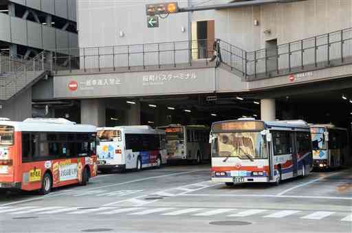 桜町バスターミナルを出入りする路線バス。県内バス事業者５社は重複路線の効率化や運行ダイヤの均等化を検討している＝１２月下旬、熊本市中央区