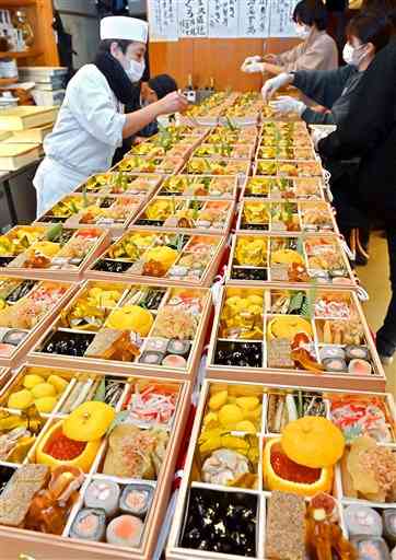 重箱に盛り付けられるおせち料理＝３０日午後、熊本市中央区