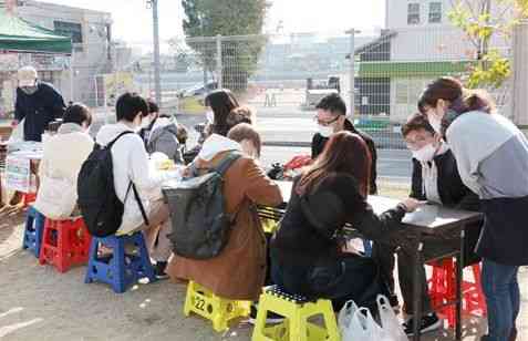 「くまもと学生食料支援プロジェクト」実行委が開いた１回目の食料配布会で、窮状を伝える大学生たち（手前）＝２０２０年１２月、熊本市中央区