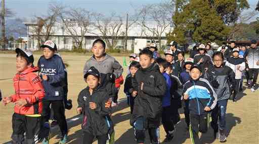 グラウンドで練習するあみつジュニアランニングクラブの小学生ら＝宇土市