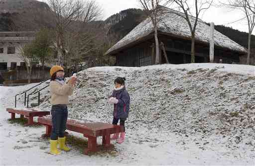 うっすらと雪化粧した子守唄公園で遊ぶ子ども＝８日午後、五木村（小野宏明）