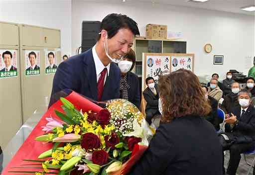荒尾市長選で無投票での再選が決まり、支持者から花束を受け取る浅田敏彦さん＝１７日午後５時４５分ごろ、同市の選挙事務所（高見伸）