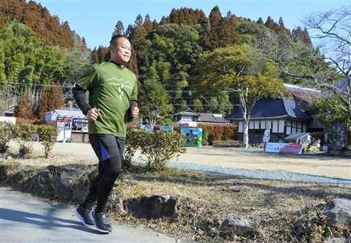 金栗四三の生家前を走るオンラインマラソン大会の参加者＝和水町