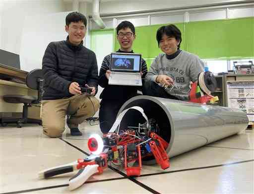 「廃炉創造ロボコン」でイノベーション賞を受賞した熊本高専熊本キャンパスのロボットと、製作した（左から）荒木駿佑さん、中村維冴さん、神崎修一さん＝合志市