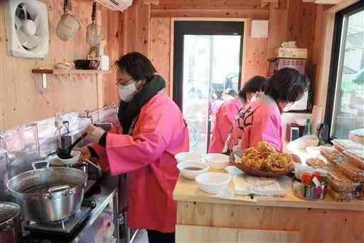 店舗内で、来店者に振る舞うぜんざいの準備をする「人吉温泉女将の会さくら会」のメンバー＝人吉市