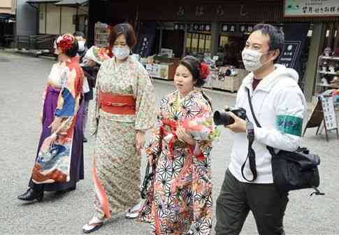 新成人らの晴れ着姿を写真に残す「ＫＩＭＯＮＯプロジェクト」に参加し、撮影に向かう坂田妙和さん（右から２人目）＝１３日、熊本市中央区