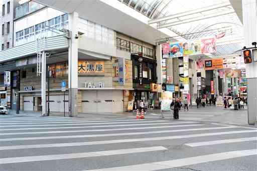 熊本の繁華街を代表する下通と銀座通りの交差点付近。田尻洋服店（正面）は１月に閉店し、約７０年の歴史を終えた＝１９日、熊本市中央区