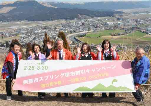 補助を利用した宿泊を呼び掛ける阿蘇市の観光関係者ら。奥に広がるのは内牧温泉街＝同市