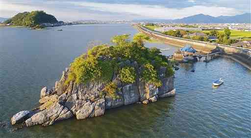 球磨川河口にあり、干潮時は陸続きとなる水島。日本書紀に登場し、国の名勝に指定されている＝20年８月２９日、八代市（高見伸、小型無人機で撮影）