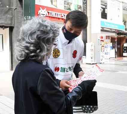 通行人にチラシを渡し、２０日の開幕戦をＰＲする火の国サラマンダーズの選手＝１４日、熊本市中央区