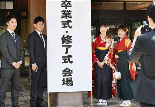 熊本大の卒業式で記念撮影する卒業生たち＝２５日午前、熊本市中央区の県立劇場（石本智）
