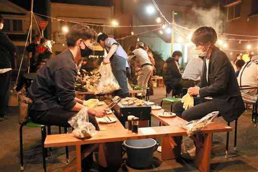 屋外イベント「小国ｎｉｇｈｔ（ナイト）」で料理を楽しむ参加者＝山都町