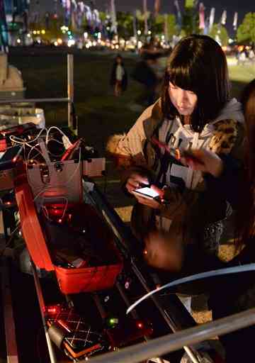 ２０１６年４月１９日、益城町の避難所で携帯電話の充電をする人たち。地震後の生活では、携帯電話が必需品となっていた（横井誠）