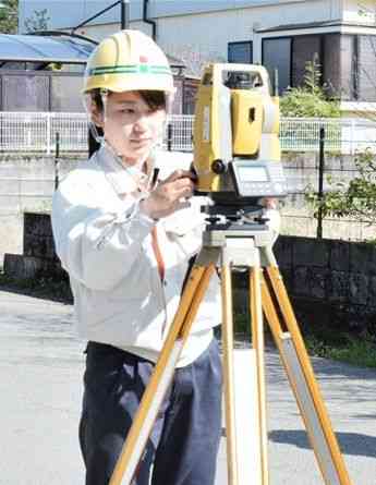 下水道の工事現場で測量する藤川優茉さん＝熊本市南区