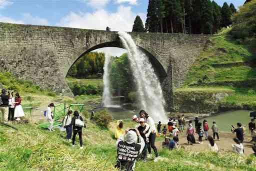 観光客が見守る中、今シーズンの放水が始まった通潤橋＝３日午後１時ごろ、山都町