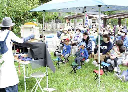 復興坂本町桜まつりで、ボランティアによる紙芝居に見入る参加者ら＝八代市