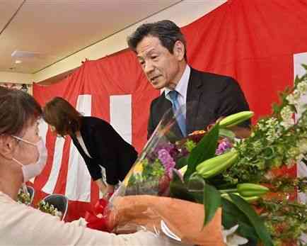 菊池市長選で無投票での３選が決まり、支持者から花束を受け取る江頭実さん＝４日午後５時５分ごろ、同市（高見伸）
