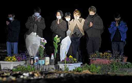 学生１人が亡くなったアパートで祈りをささげる東海大の学生や卒業生ら＝１６日午前１時１５分ごろ、南阿蘇村（植山茂）